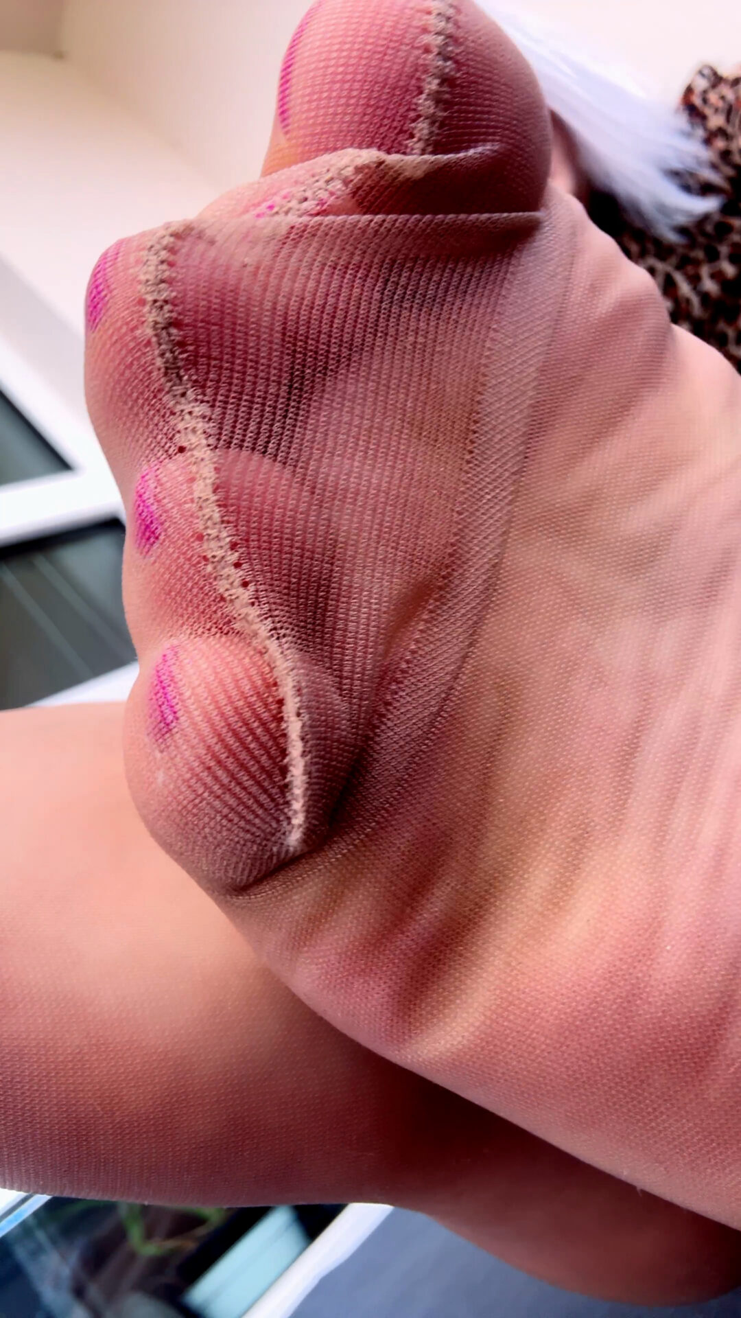 Playing with tan pantyhose soles on the balcony